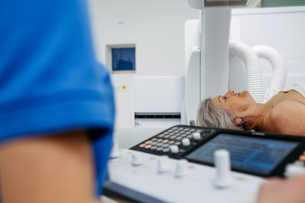 Senior patient undergoing X-ray on tilting wall unit