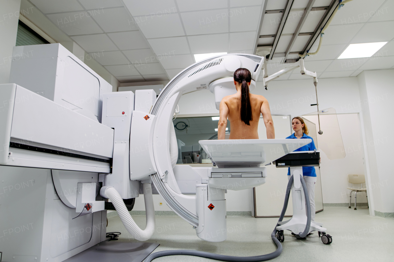 Female patient preparing for diagnostic imaging with modern X-ray system