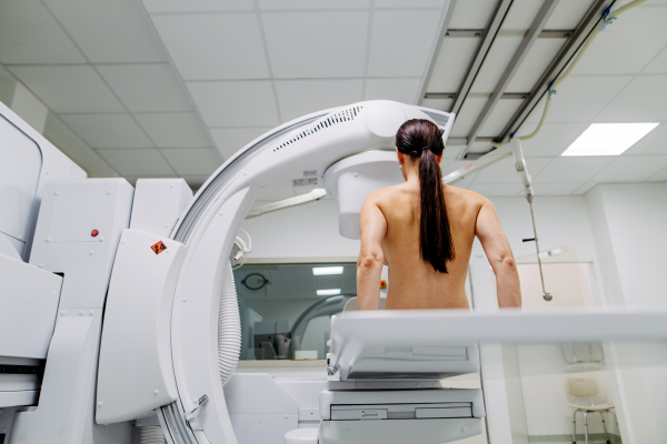 Female patient preparing for diagnostic imaging with modern X-ray system