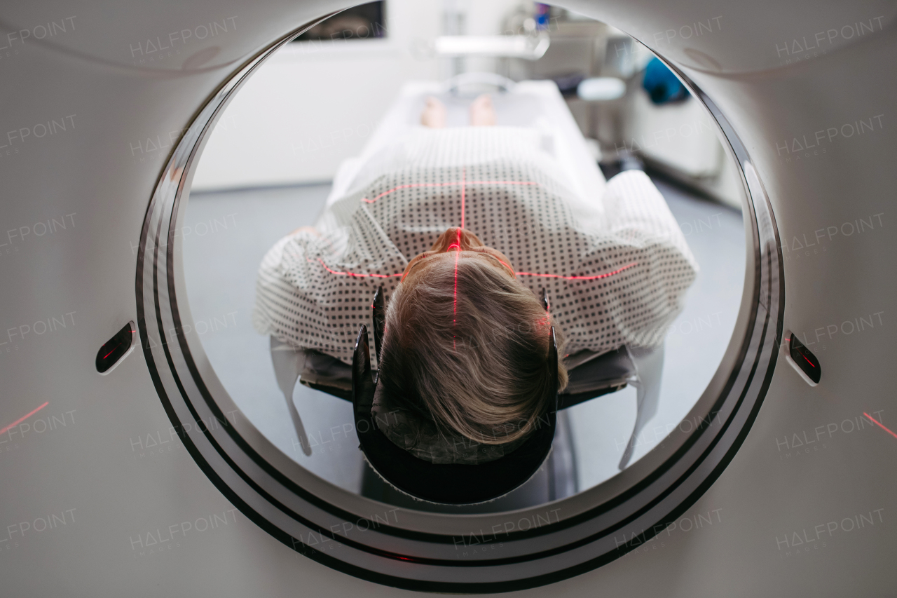 CT scanner view of senior patient during medical imaging procedure. Older woman undergoing MRI scan.