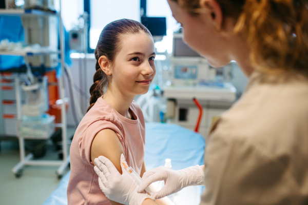 Child getting vaccinated during medical exam at pediatric clinic.