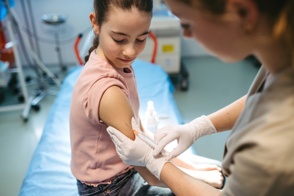 Child getting vaccinated during medical exam at pediatric clinic.