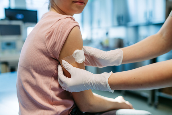 Nurse is caring for the injection wound after vaccination.