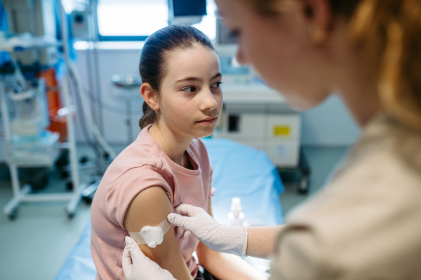 Nurse is caring for the injection wound after vaccination.