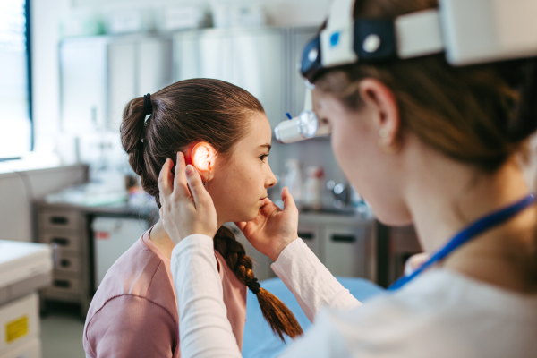 Ear examination of a young girl at a medical clinic.