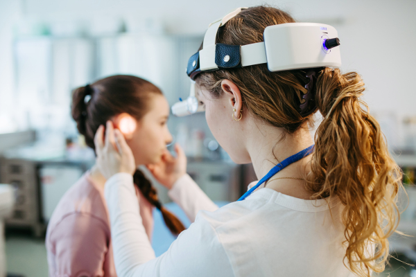 Ear examination of a young girl at a medical clinic.