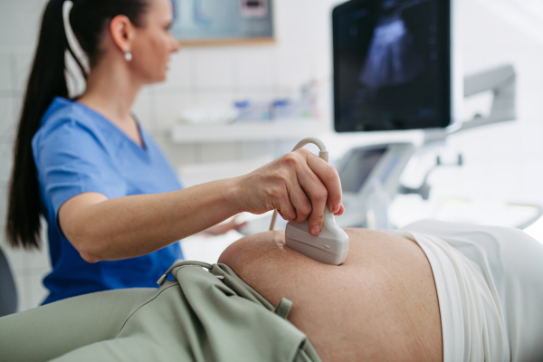 Doctor performing abdominal ultrasound on elderly woman. Preventive care.