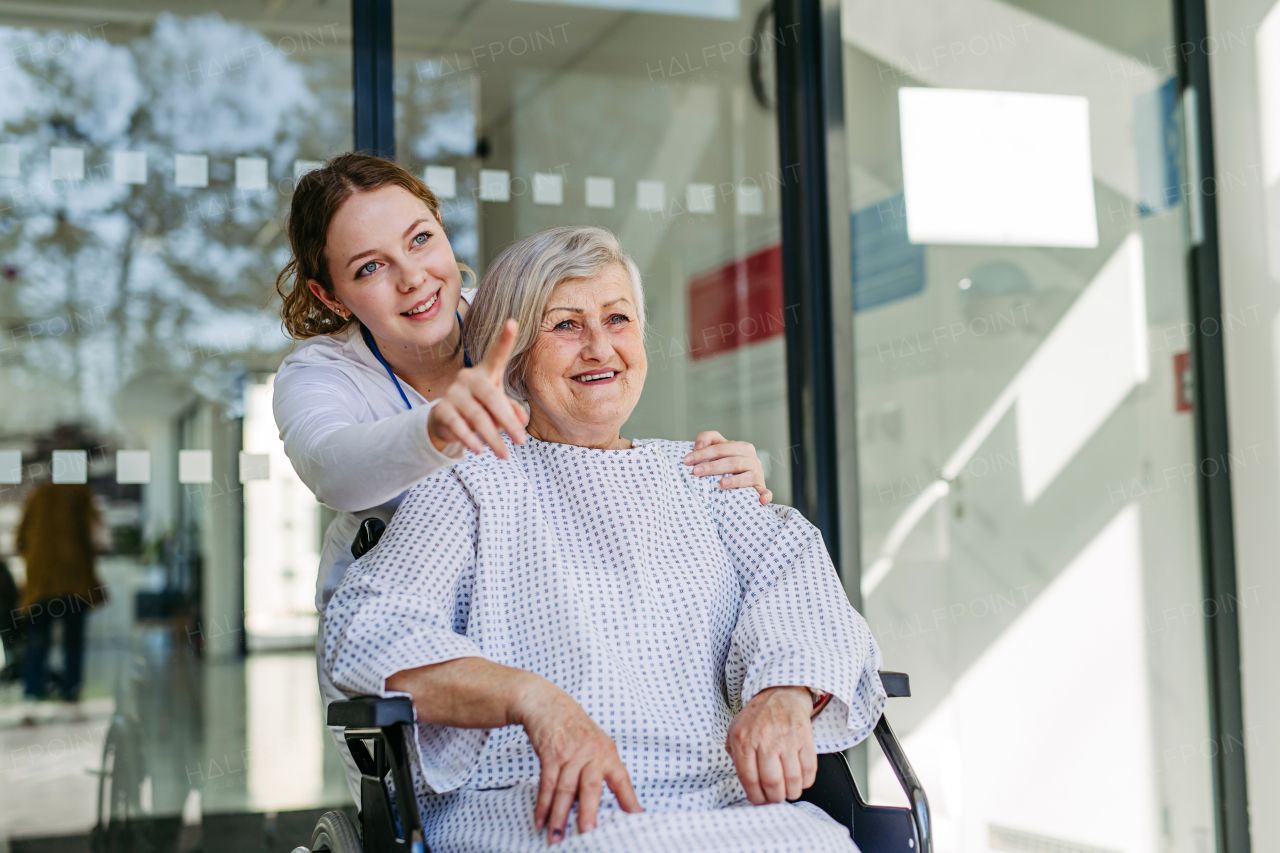 Elderly patient in wheelchair and female physician smiling. Senior health care.