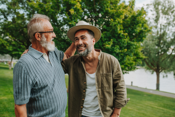 Father and adult son sharing a joyful moment outdoors. Fathers day concept.
