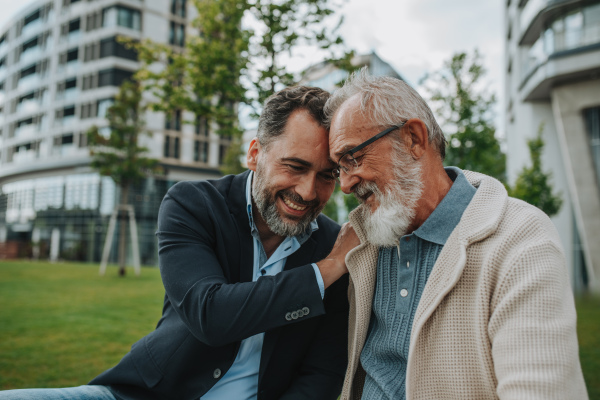 Father and adult son sharing a joyful moment outdoors. Fathers day concept.
