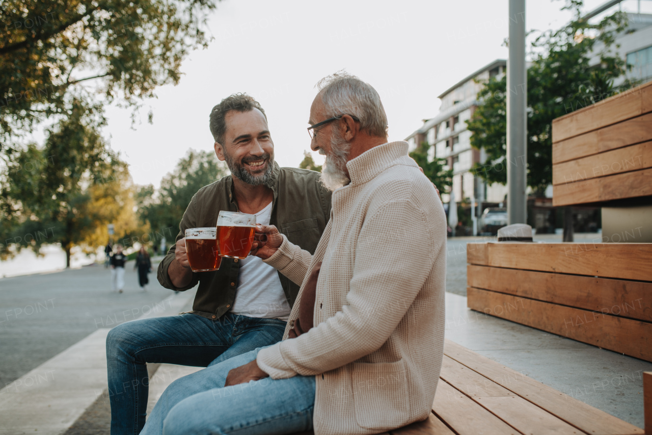 Father and son enjoying beer together outdoors. Fathers day concept.