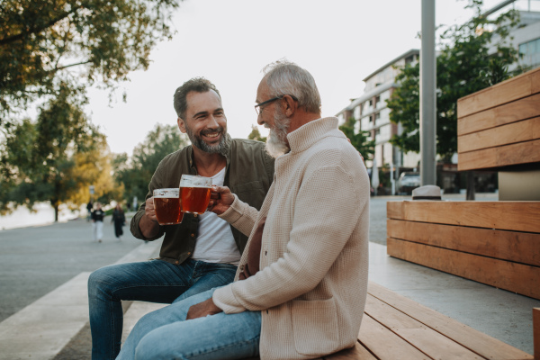 Father and son enjoying beer together outdoors. Fathers day concept.