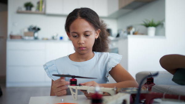 Close up of kids building their first homemade robot at home. Educational robotic kit for children.