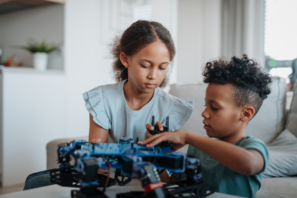 Kids playing with drone at home. Educational robotic kit for children.