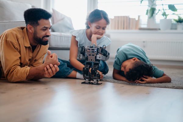 Father teaching kids about STEM, robotics, and discussing technology at home.