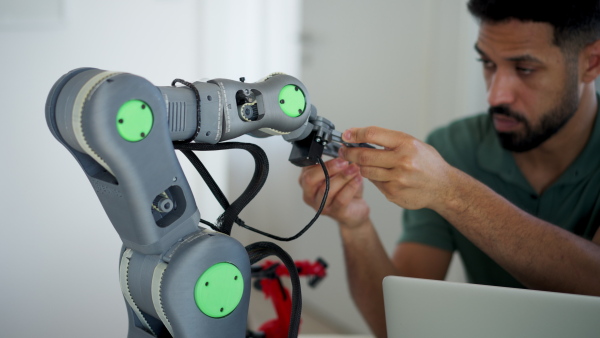 Engineer struggling with a technical problem while building robotic arm at home.