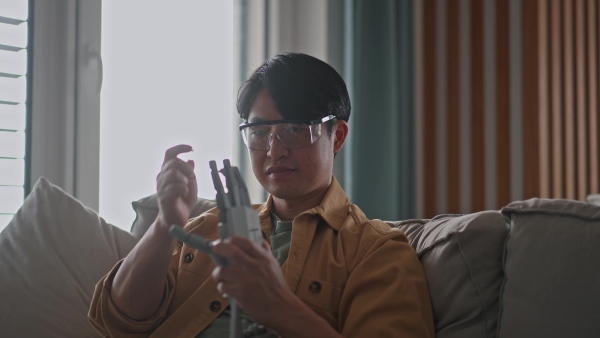 Young engineer building a robotic arm at home. Robotics concept.