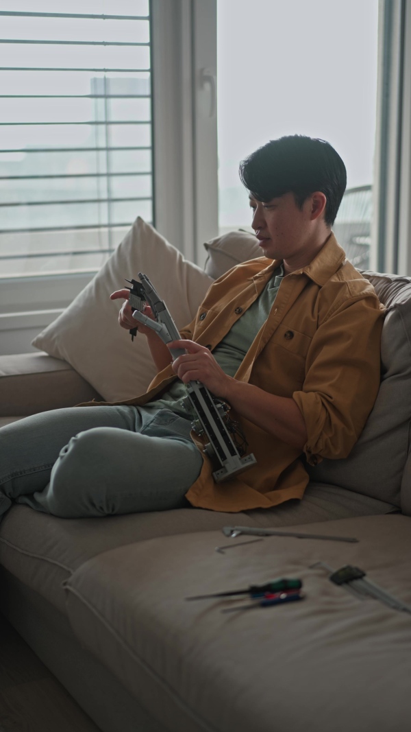 Young engineer building a robotic arm at home. Robotics concept.