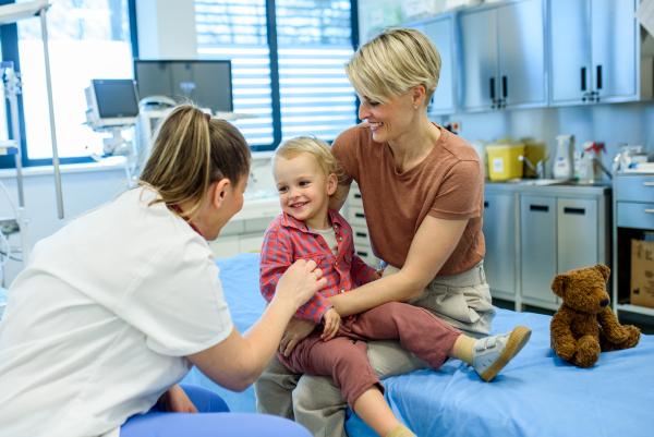 Female pediatrician examing little boy during preventive health check up.