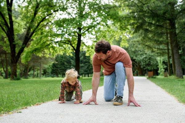 Father lining up to have a running race with his young son.