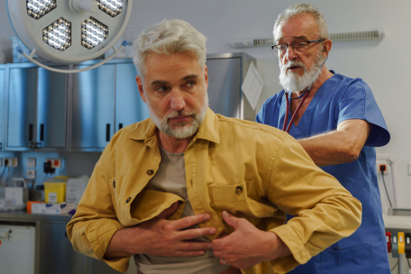 Doctor examining sick patient, listening to breathing with stethoscope.