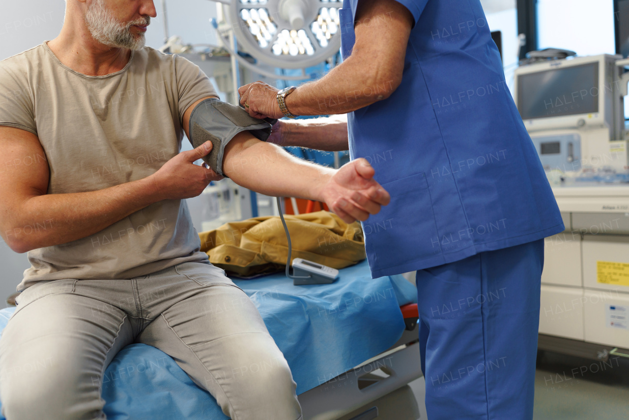 Doctor taking patient's blood pressure using a digital blood pressure monitor.