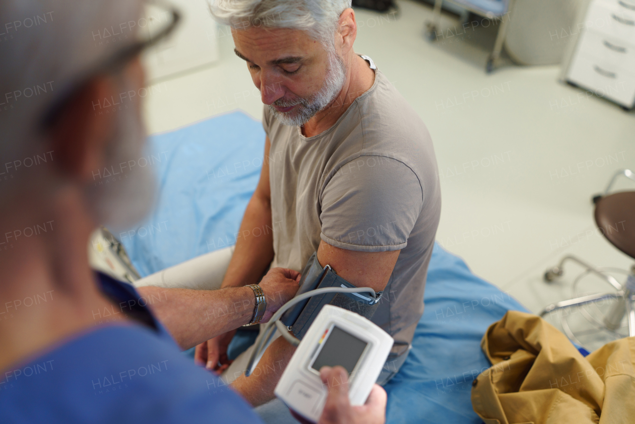 Doctor taking patient's blood pressure using a digital blood pressure monitor.