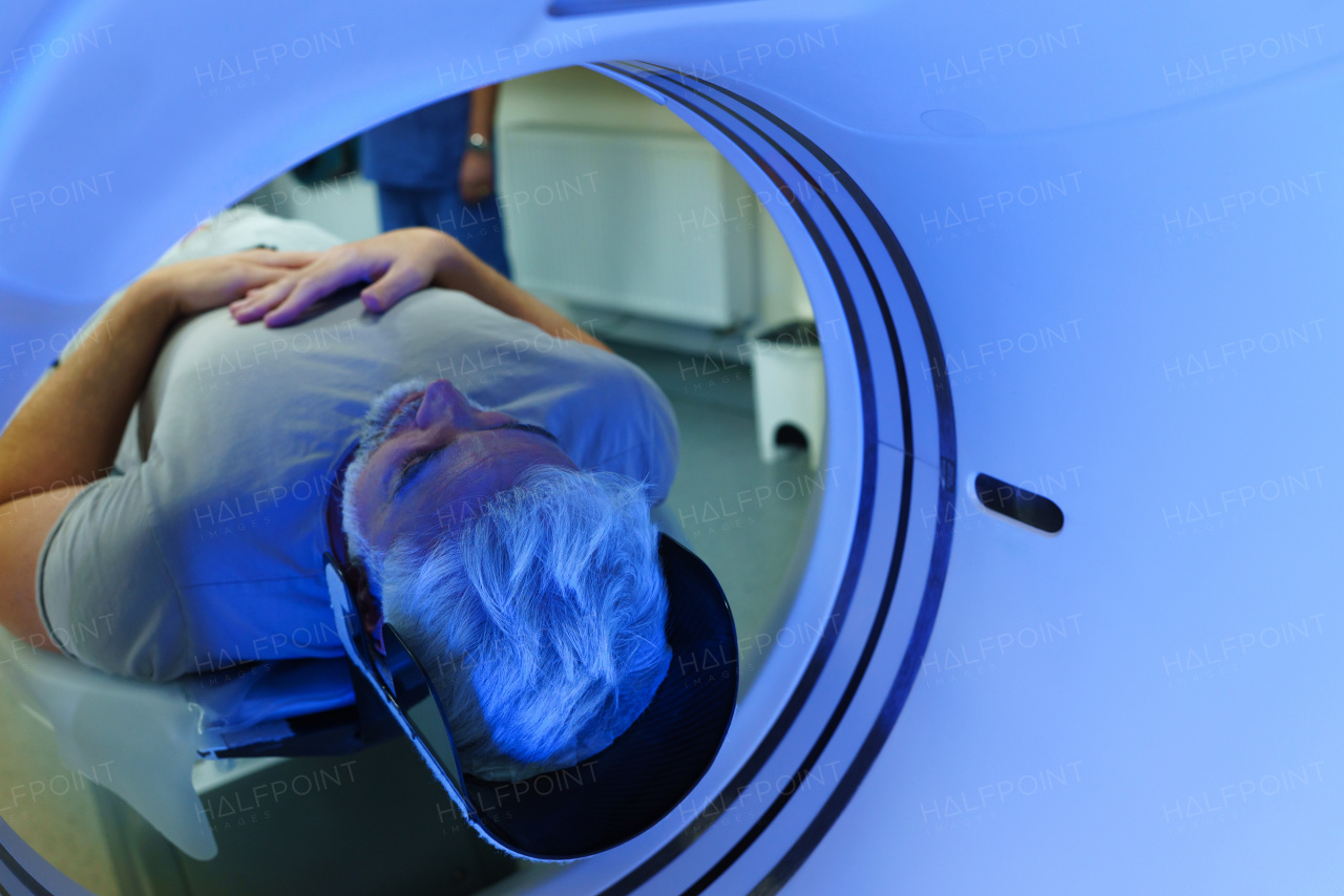Male patient undergoing CT scan examination in a hospital.
