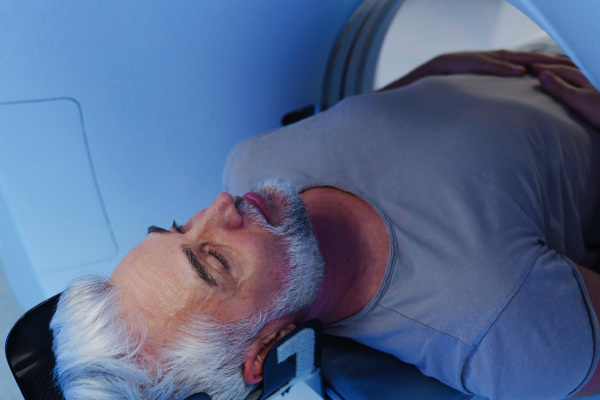 Male patient undergoing CT scan examination in a hospital.