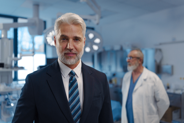 Portrait of pharmaceutical sales representative with doctor standing behind him. Hospital director, manager of private medical clinic.