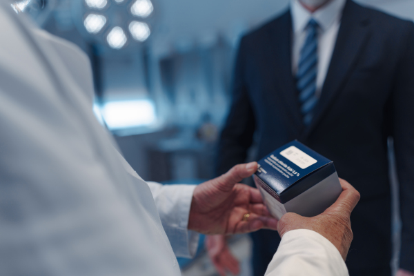 Close up of medical sales representative presenting new medication to doctor. . Hospital setting.