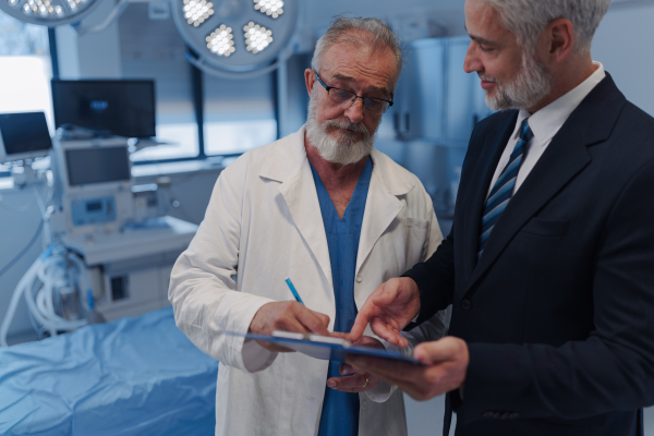 Doctor signing contract with pharmaceutical representative, successful deal.