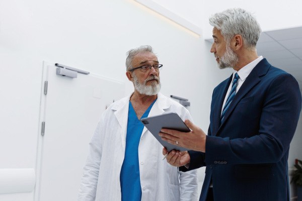 Doctor talking with pharmaceutical representative, hospital setting.
