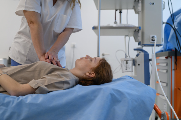 Doctors performing CPR on teenage patient in critical condition, emergency resuscitation.