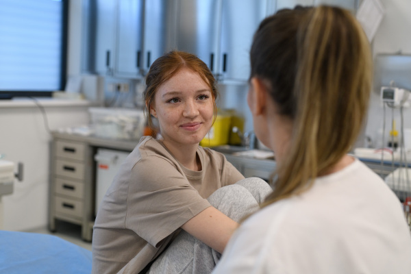 Teenage girl confiding in female doctor about personal and health problems.