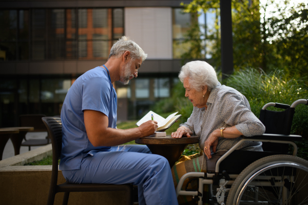 Doctor explaining medication to senior patient and answering her questions about diagnosis.