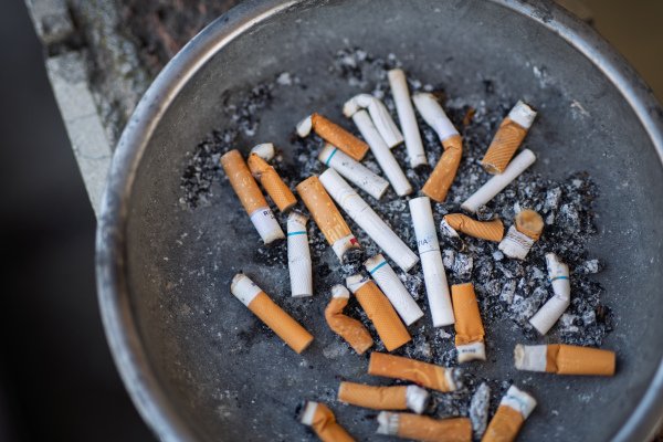 Close-up of overflowing ashtray with cigarette butts and ashes