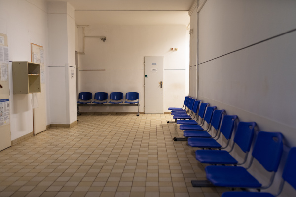 Worn corridor in municipal hospital with multiple clinics and seating