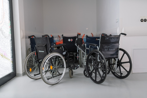 Outdated ambulance wheelchairs in abandoned hallway