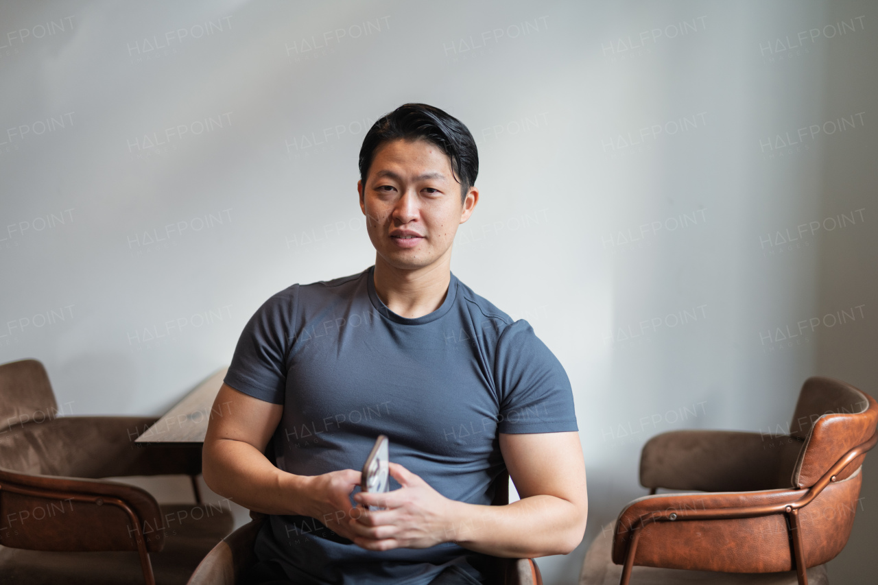 Portrait of young muscular Asian man, looking at camera.