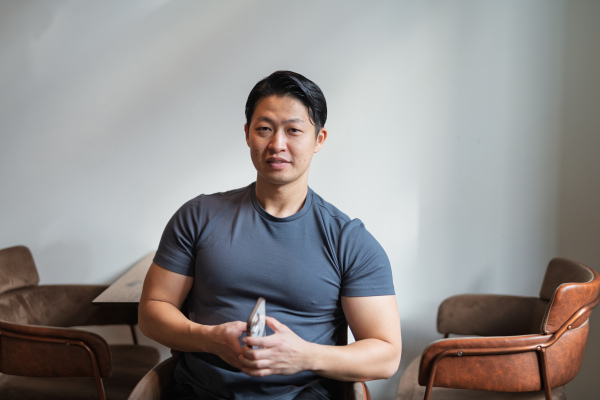 Portrait of young muscular Asian man, looking at camera.