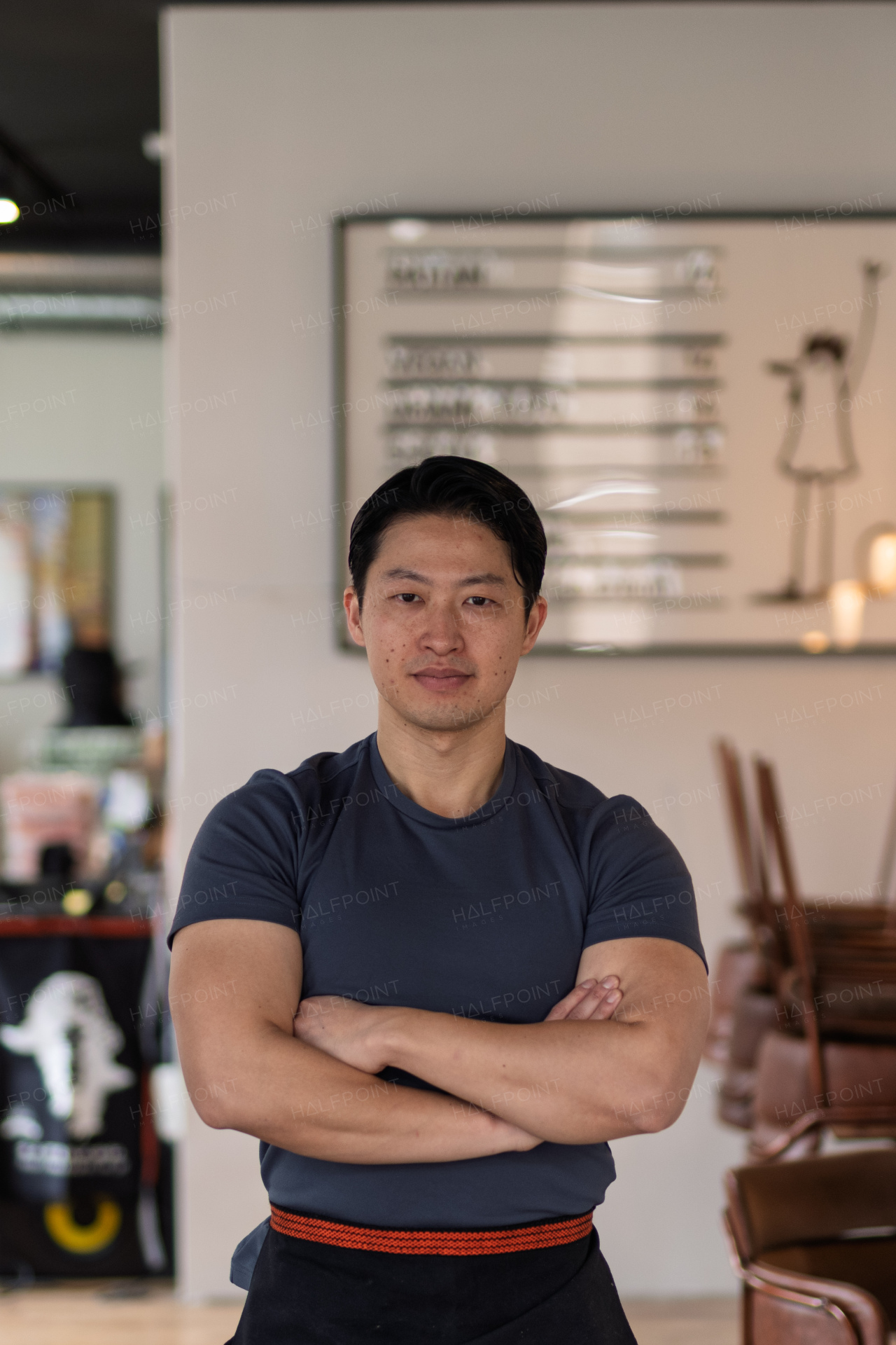 Athletic Asian man looking away in casual setting, smiling.