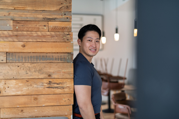 Athletic Asian man looking away in casual setting, smiling.