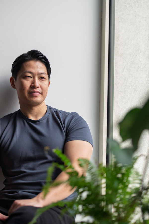 Confident young man sitting by the window in natural light, resting.