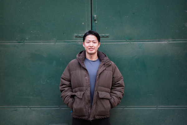 Portrait of young handsome Asian man outdoors during cold day. Looking at camera.