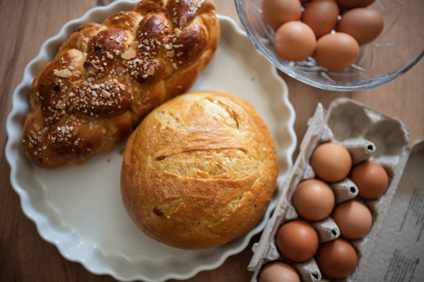Homemade bread and eggs on rustic kitchen table. Traditional breakfast ingredients.