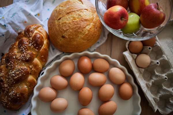 Fresh ingredients for homemade breakfast. Eggs, bread and fruit on rustic wooden table.