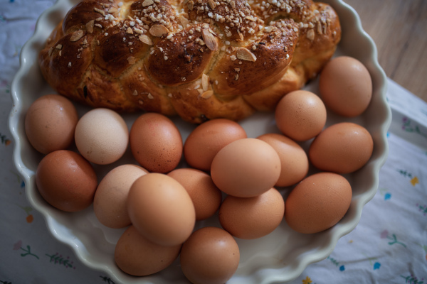 Homemade braided bread and eggs on rustic kitchen table. Traditional breakfast ingredients.