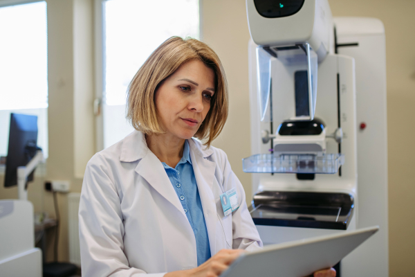 Female doctor preparing for breast screening exam, reviewing results.