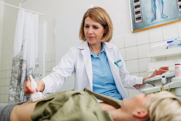 Female patient undergoing abdominal ultrasound screening. Early pregnancy check-up.
